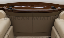 Close up of drink rail with dark wood tones in newly refurbished Falcon 2000 by Duncan Aviation