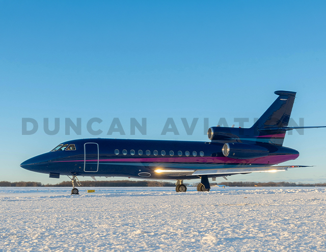 Falcon 900 painted by Duncan Aviation in rich navy with magenta and light blue stripe