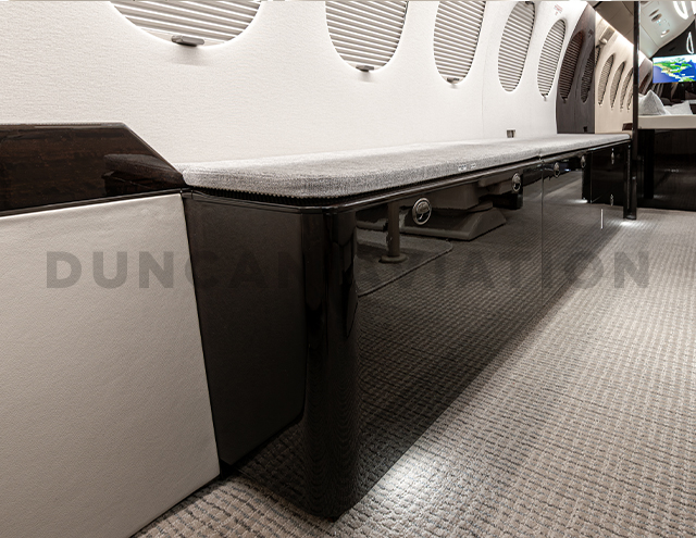 Close up view of dark wood credenza in refurbished Falcon 7X by Duncan Aviation
