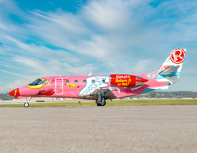 Side view of the Ripley's Believe It or Not! Flying Pig Citation by Duncan Aviation featuring nose ring, rubber chicken earring, and goggles.