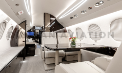 Creamy interior of refurbished Falcon 7X with dark wood accents by Duncan Aviation
