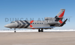 Exterior of Falcon 900 with gray paint and dark gray and red accents in X pattern