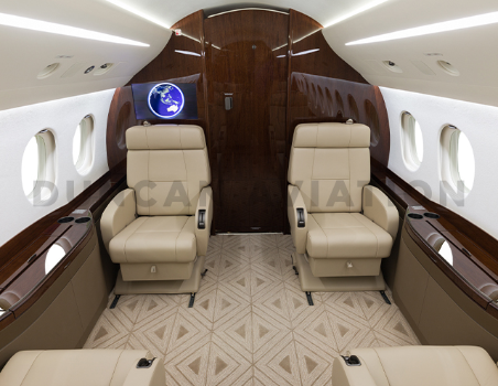 Interior of newly refurbished Falcon 2000 by Duncan Aviation with tan upholstery and dark wood accents